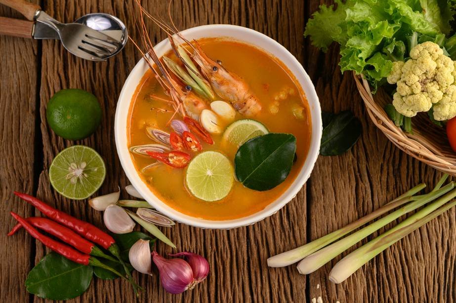 Tom Yum Kung Thai hot spicy soup shrimp with lemon grass,lemon,galangal and chilli on wooden background Thailand Food